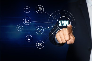 Image of Social media marketing concept. Man touching virtual icon SMM on dark background, closeup