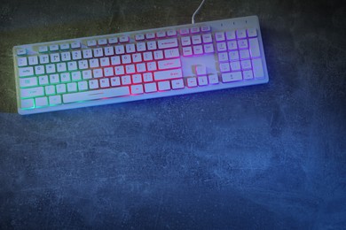 Photo of Modern RGB keyboard on grey table, top view. Space for text