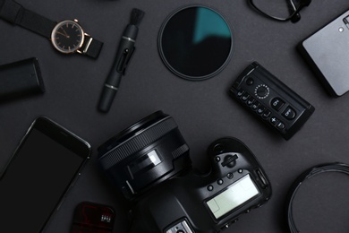 Photo of Flat lay composition with equipment for professional photographer on dark background