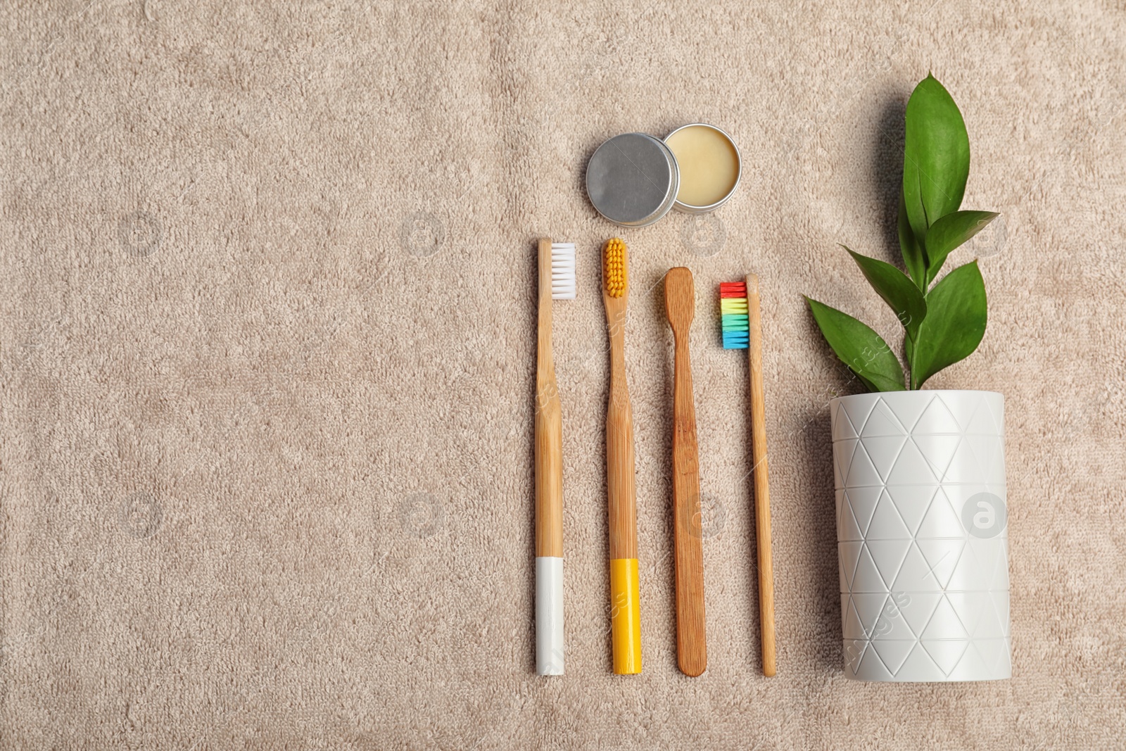 Photo of Flat lay composition with bamboo toothbrushes and space for text on towel