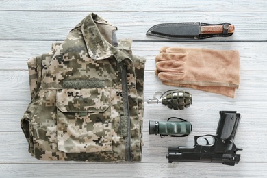 Set of military outfit on wooden background, flat lay