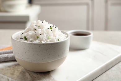 Bowl of tasty cooked rice served on table. Space for text