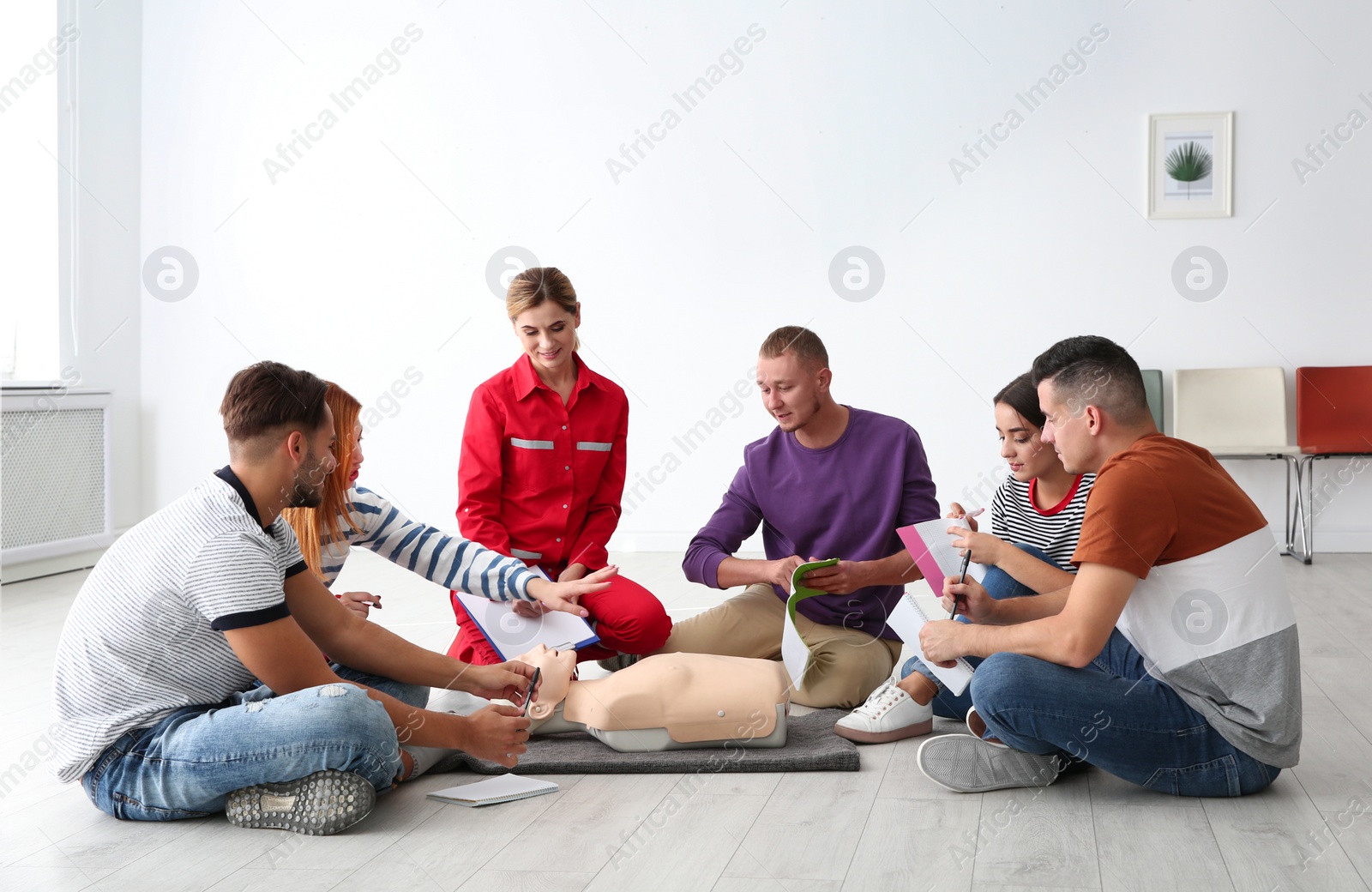 Photo of Group of people with instructor at first aid class indoors