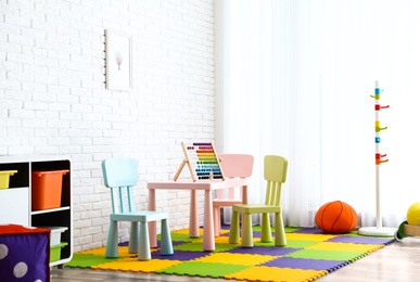 Photo of Stylish playroom interior with toys and modern furniture