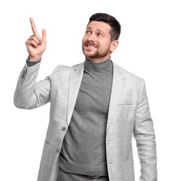 Handsome bearded businessman in suit pointing at something on white background