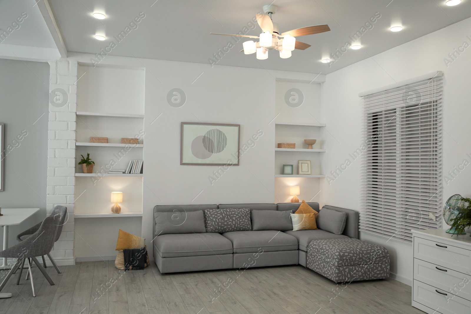 Photo of Comfortable furniture, ceiling fan and accessories in stylish living room