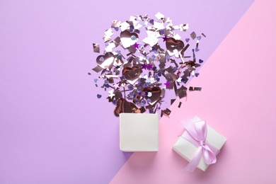 Flat lay composition with shiny confetti and box on color background