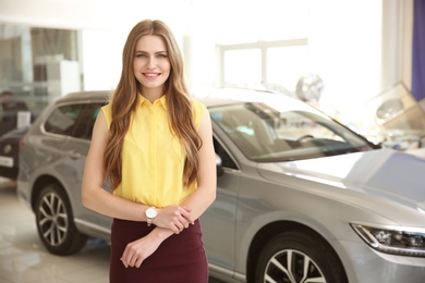 Photo of Portrait of young saleswoman in car dealership