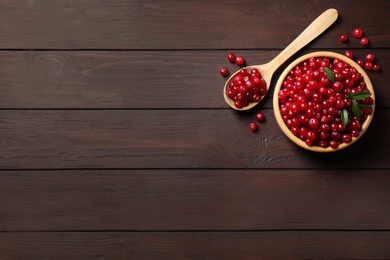 Photo of Fresh cranberry on wooden table, flat lay. Space for text