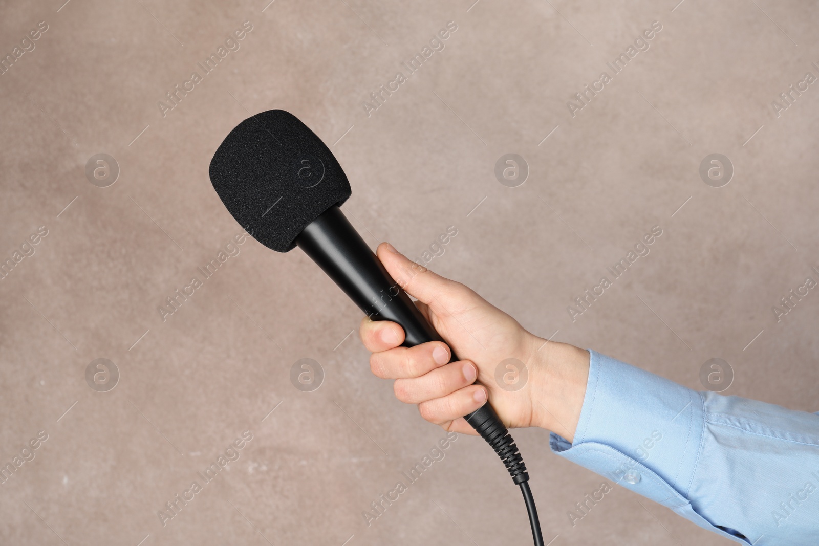 Photo of Woman holding microphone on color background, closeup