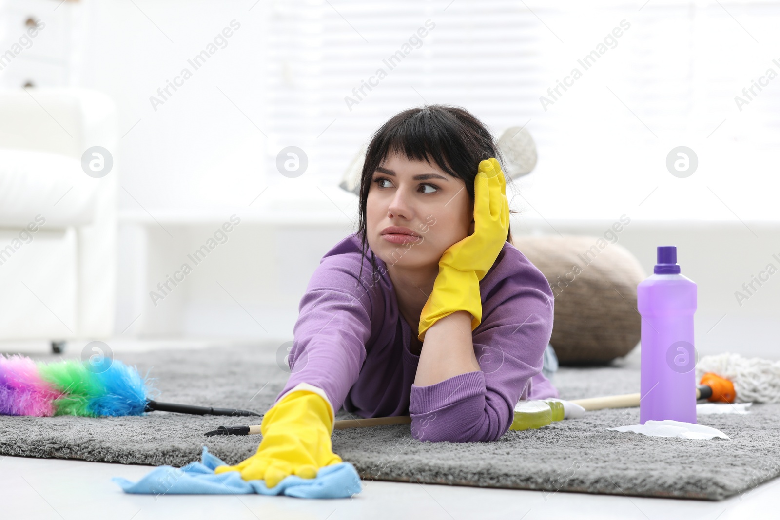 Photo of Lazy woman procrastinating while cleaning at home