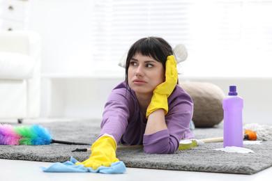 Photo of Lazy woman procrastinating while cleaning at home