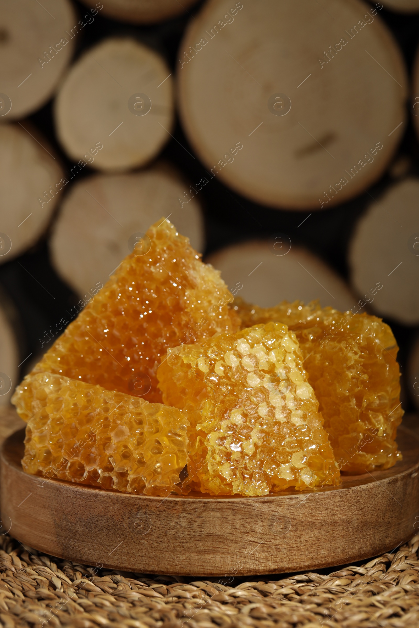 Photo of Natural honeycombs on wicker mat, closeup. Space for text