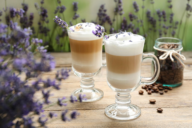 Delicious latte with lavender and coffee beans on wooden table