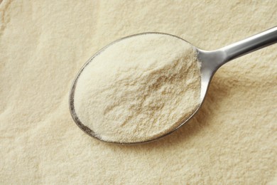 Agar-agar powder and spoon as background, top view