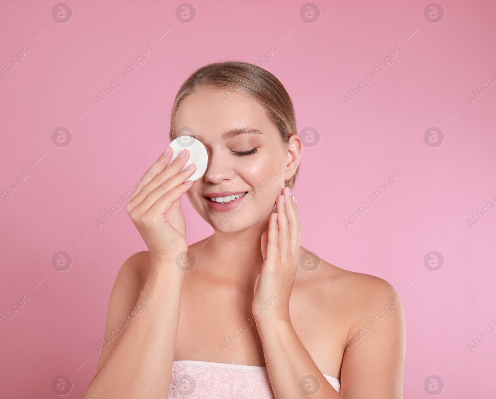 Photo of Beautiful young woman with cotton pad on pink background