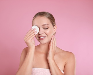 Photo of Beautiful young woman with cotton pad on pink background