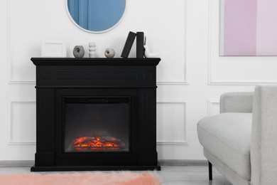 Photo of Black stylish fireplace near comfortable sofa in cosy living room