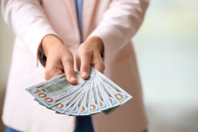 Woman with American money on light background, closeup