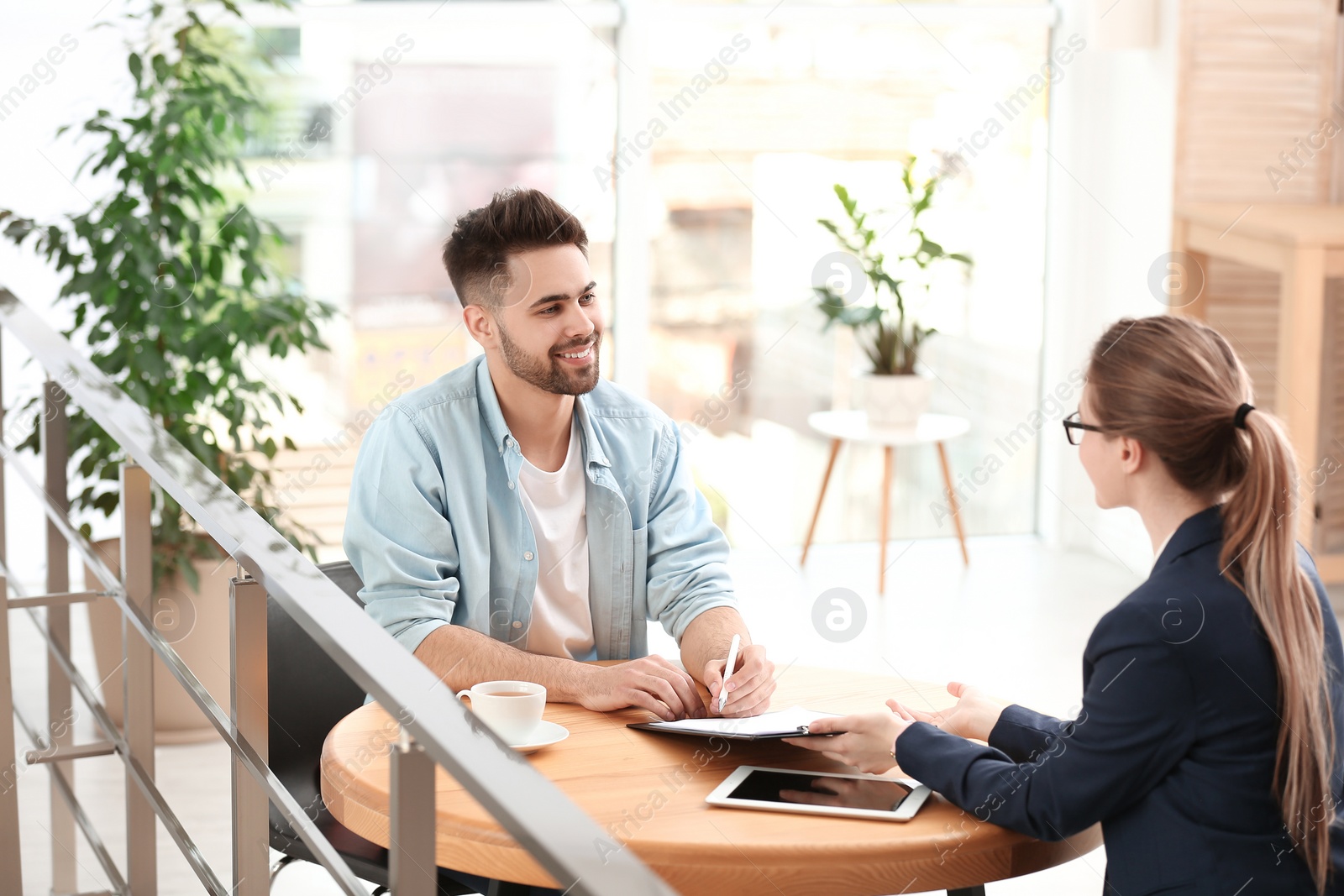 Photo of Female insurance agent working with client in office