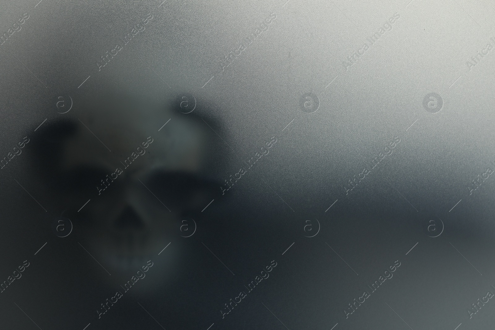 Photo of Silhouette of creepy ghost with skull behind cloth, space for text