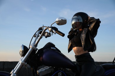 Photo of Woman in helmet sitting on motorcycle outdoors