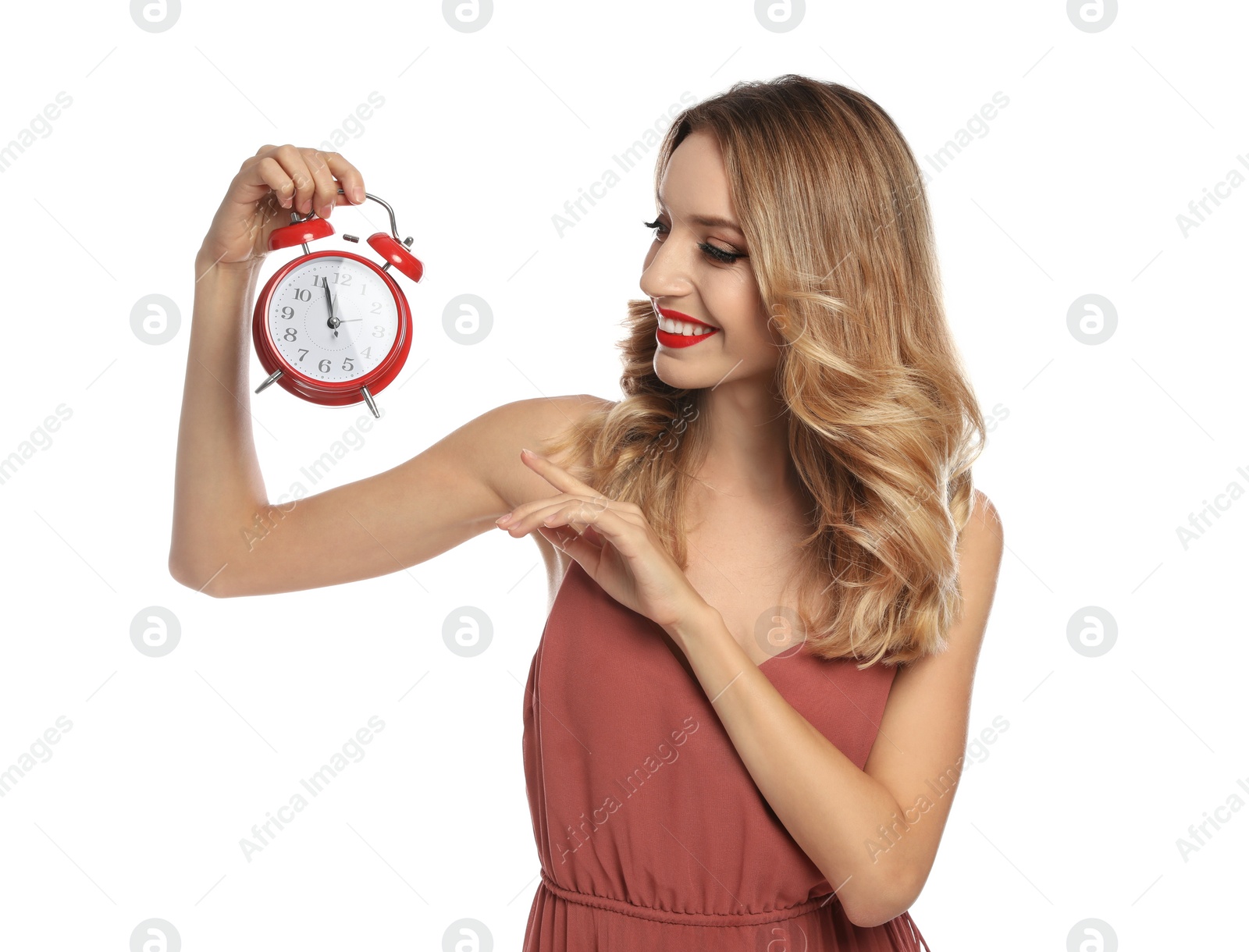 Photo of Happy young woman with alarm clock on white background. Christmas time