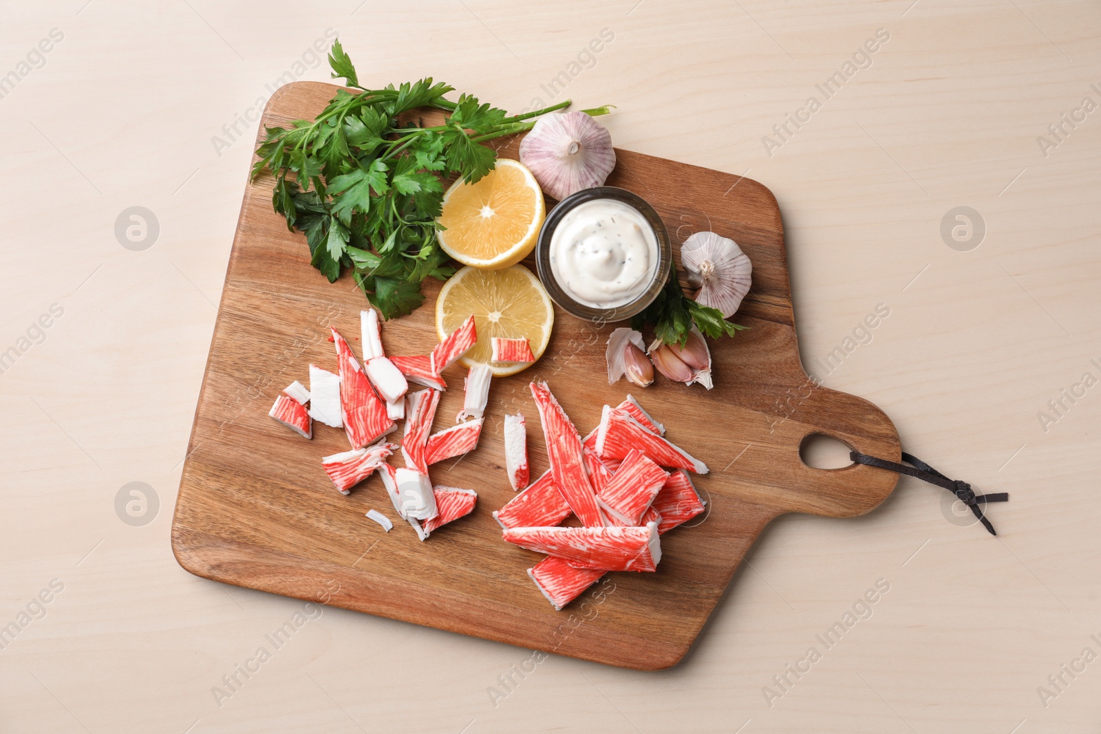 Photo of Delicious crab sticks served on wooden table, top view