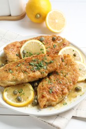 Delicious chicken piccata on white table, closeup