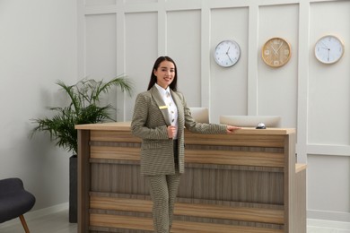 Photo of Portrait of beautiful receptionist near counter in hotel