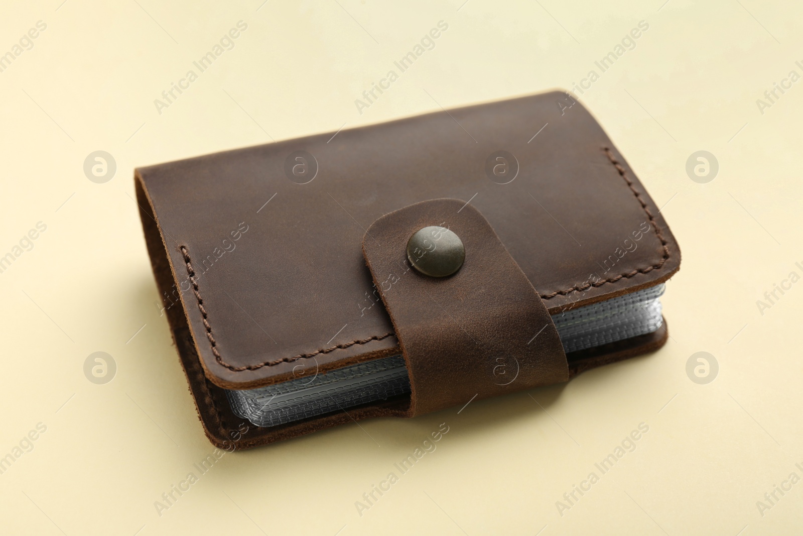 Photo of One leather card holder on beige background