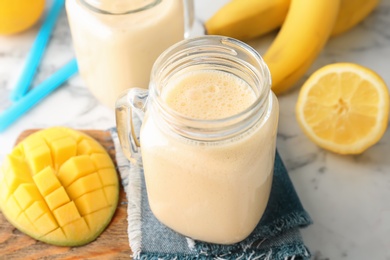 Mason jars with healthy detox smoothie and ingredients on table