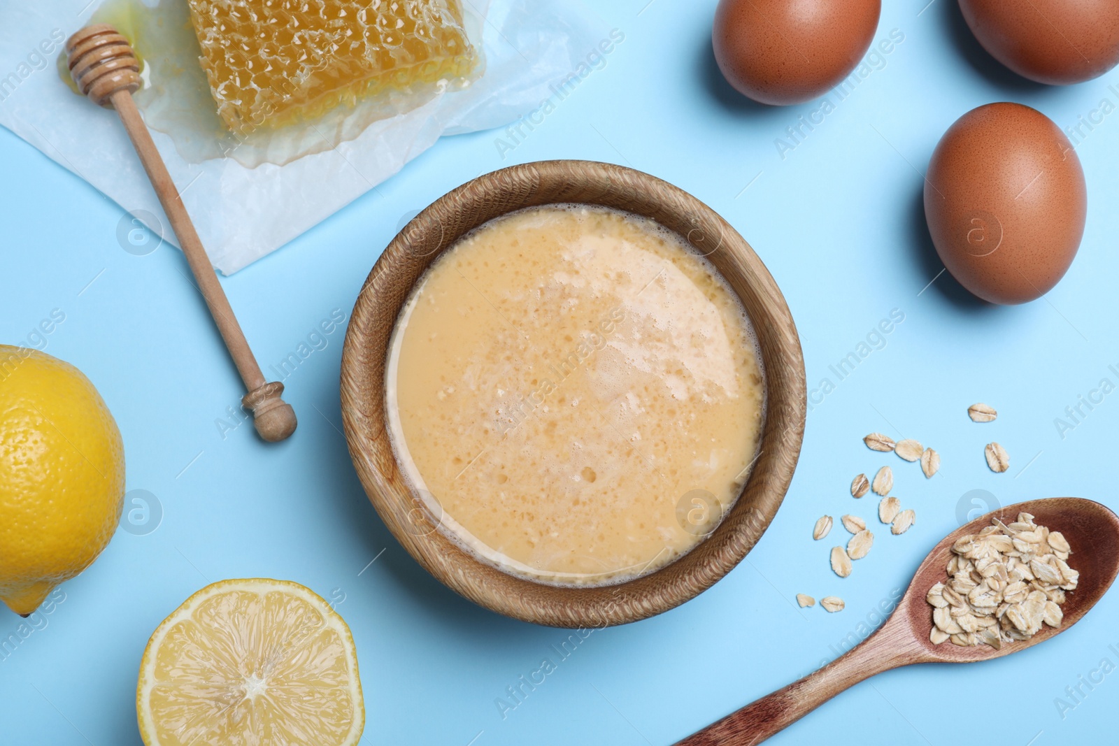 Photo of Homemade hair mask and ingredients on light blue background, flat lay