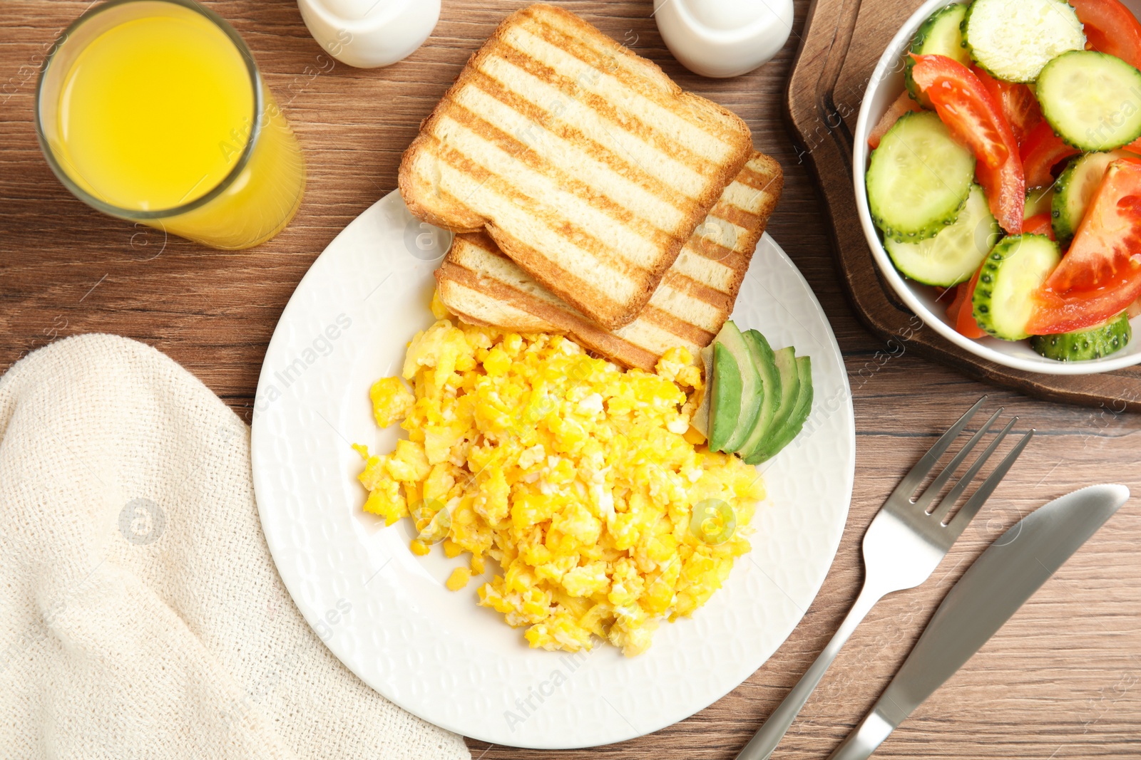 Photo of Delicious breakfast with scrambled eggs served on wooden table, flat lay