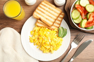 Delicious breakfast with scrambled eggs served on wooden table, flat lay