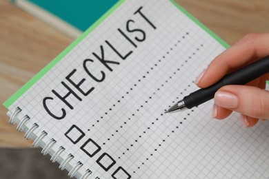 Woman filling Checklist with pen, closeup view