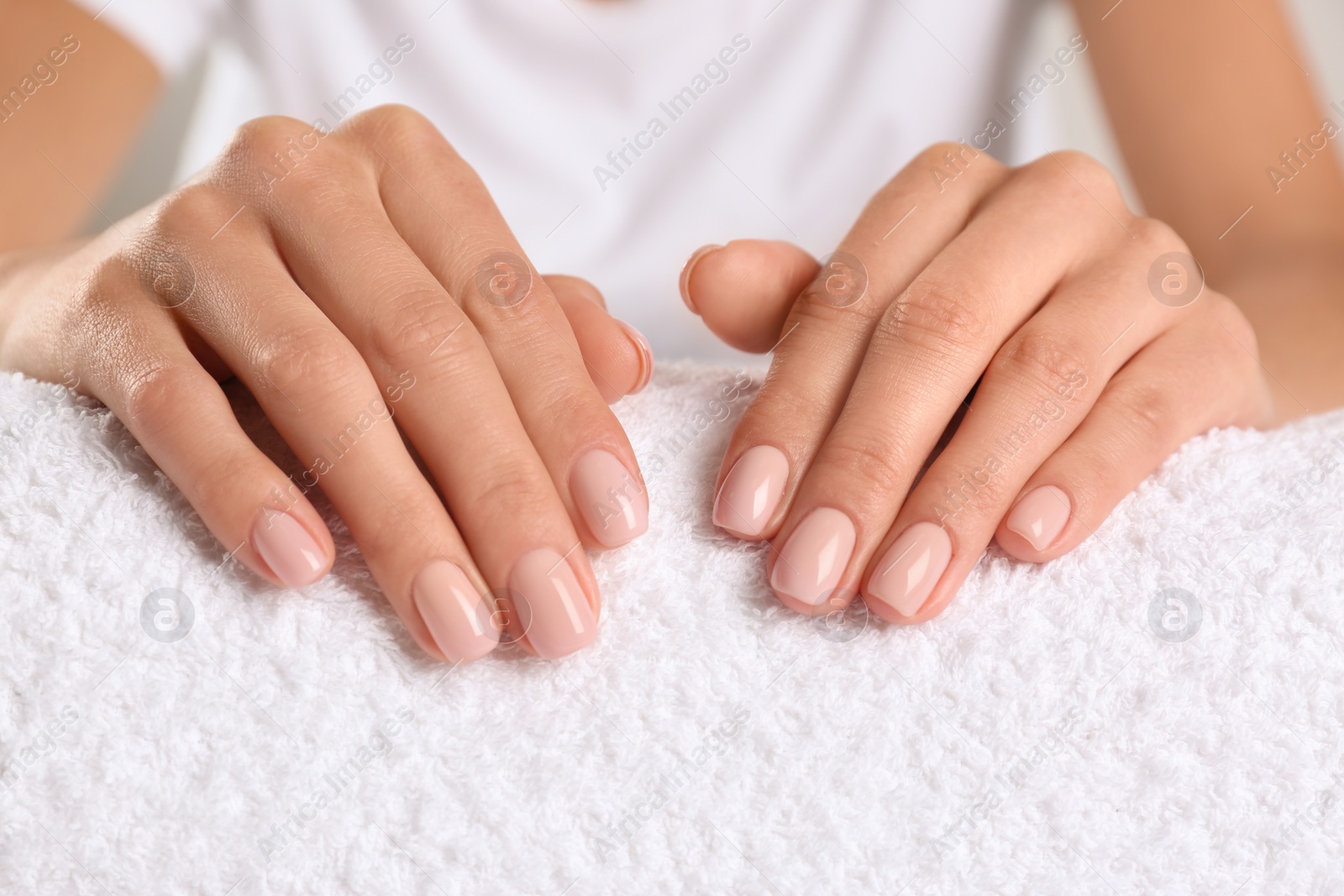 Photo of Closeup view of beautiful female hands on towel. Spa treatment