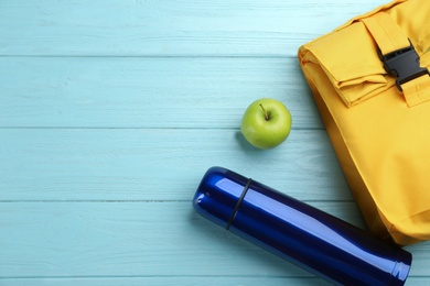 Photo of Flat lay composition with thermos on turquoise wooden background, space for text