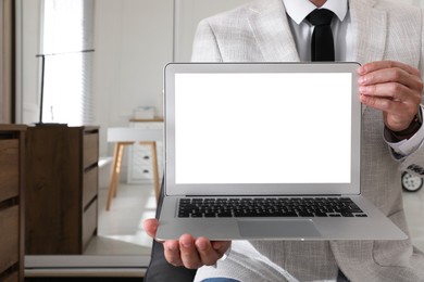 Photo of Businessman with modern laptop indoors, closeup. Space for design