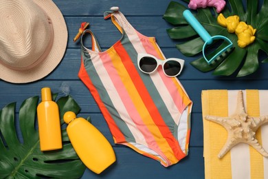 Flat lay composition with beach accessories on blue wooden background