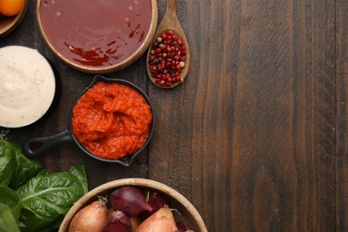 Photo of Different marinades and products on wooden table, flat lay. Space for text