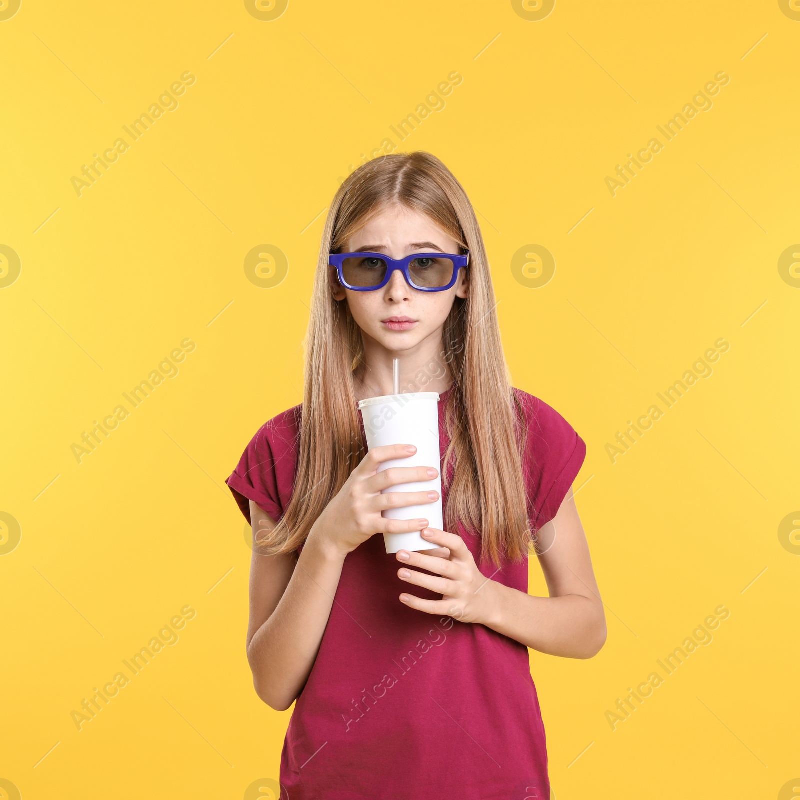 Photo of Emotional teenage girl with 3D glasses and beverage during cinema show on color background