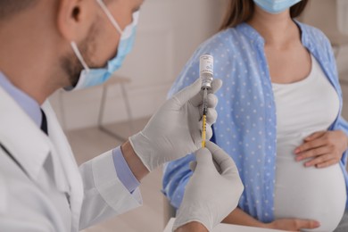 Photo of Pregnant woman ready for vaccination against coronavirus in doctor's office, closeup