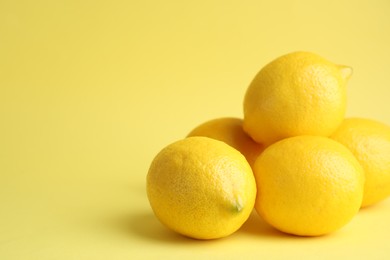 Fresh ripe lemons on yellow background. Space for text