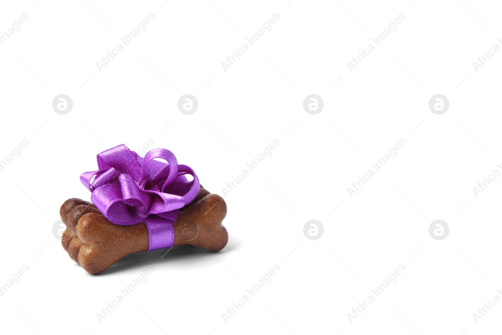 Photo of Bone shaped dog cookies with purple bow on white background, space for text