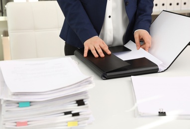 Photo of Woman working with documents at table in office, closeup