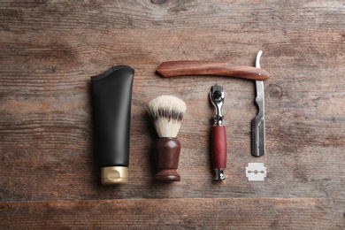 Photo of Flat lay composition with tube of men's cosmetic product on wooden background. Space for design