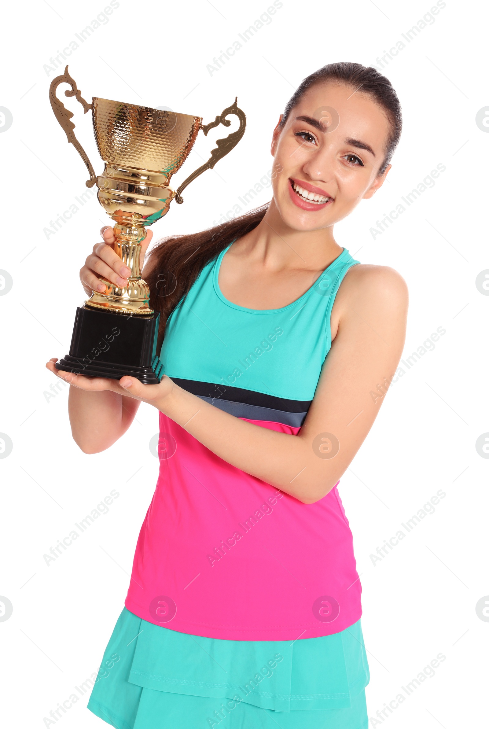 Photo of Portrait of happy young woman in tennis dress holding gold trophy cup on white background