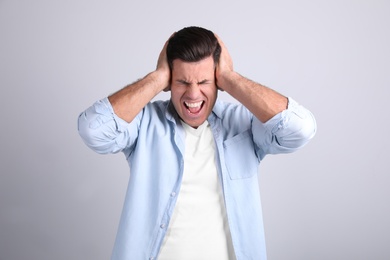 Photo of Portrait of stressed man on light background