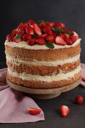 Tasty cake with fresh strawberries and mint on gray table